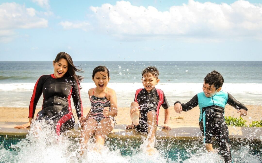 mom and her children playing water in the beach