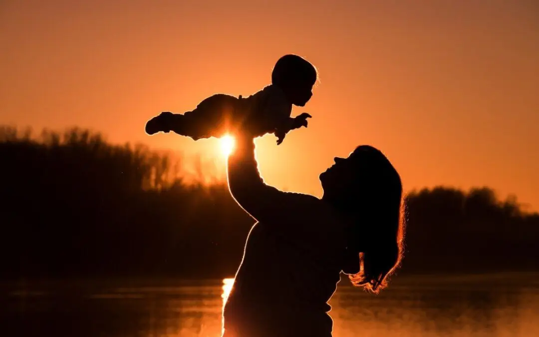 a mother lifting up her baby